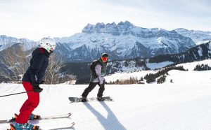 Un skieur et un snowboardeur sur une psite de ski