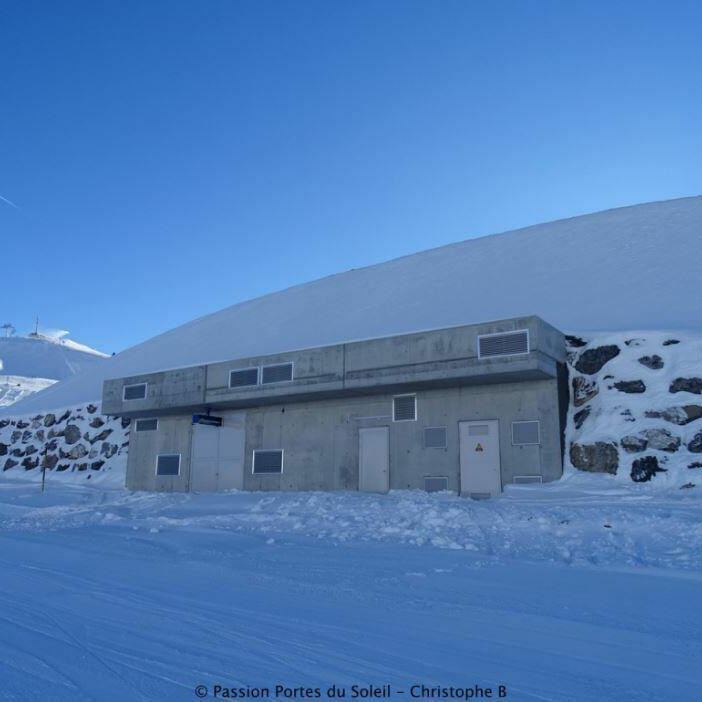 Façade de la salle des machines au milieu d'un paysage enneigé