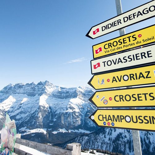 Différents panneaux de directions au sommet d'une montagne enneigée